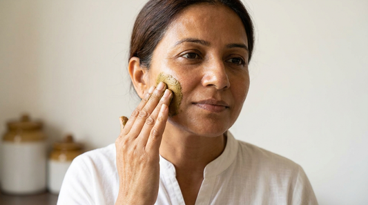 Indian woman applying natural herbal Ayurvedic face pack on glowing skin